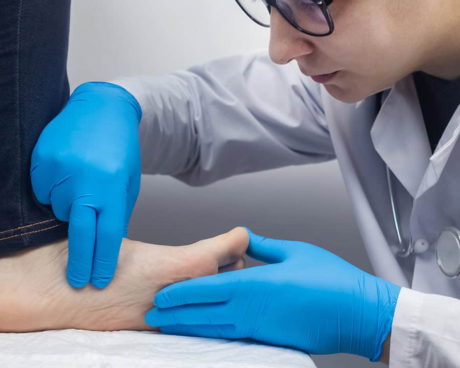 A physio examines a woman's plantar fasciia after foot pain