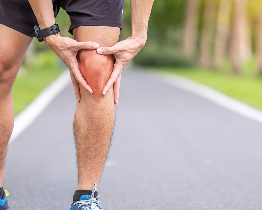 Young adult male runner with knee ache due to inflammation